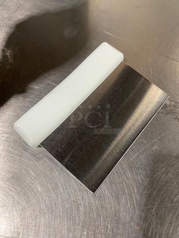 Stainless steel dough cutter with white grip handle, new Jimmy John's style, featured on metal surface.