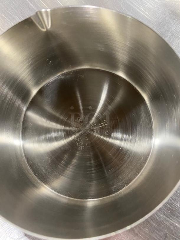 New commercial stainless steel measuring cup set, interior marked with 1 cup and 250 ml measurements, pristine condition.