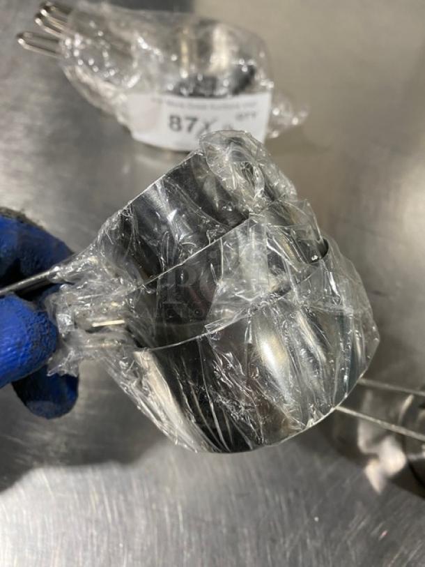 New commercial stainless steel measuring cup set in packaging, includes multiple cups. Item #877 visible on label.