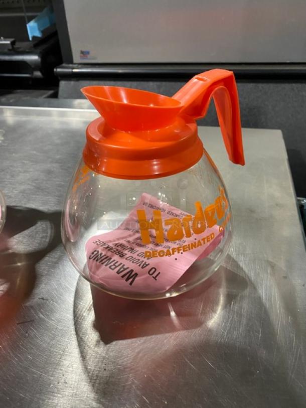 Duran Hardee's decaffeinated glass coffee decanter, new condition, orange handle, commercial use, clear and orange markings.