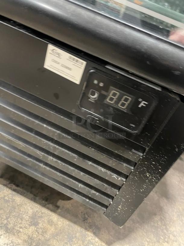 Kool-It commercial freezer, model 163LX46FB, black with double glass doors, digital display showing 88°F, on casters, includes poly coated wire racks.