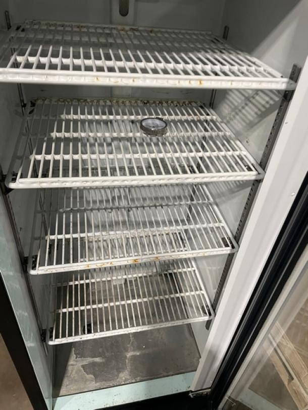 Avantco 178GDC10 refrigerated merchandiser, black, swing glass door, poly-coated wired racks, 115V, on legs.