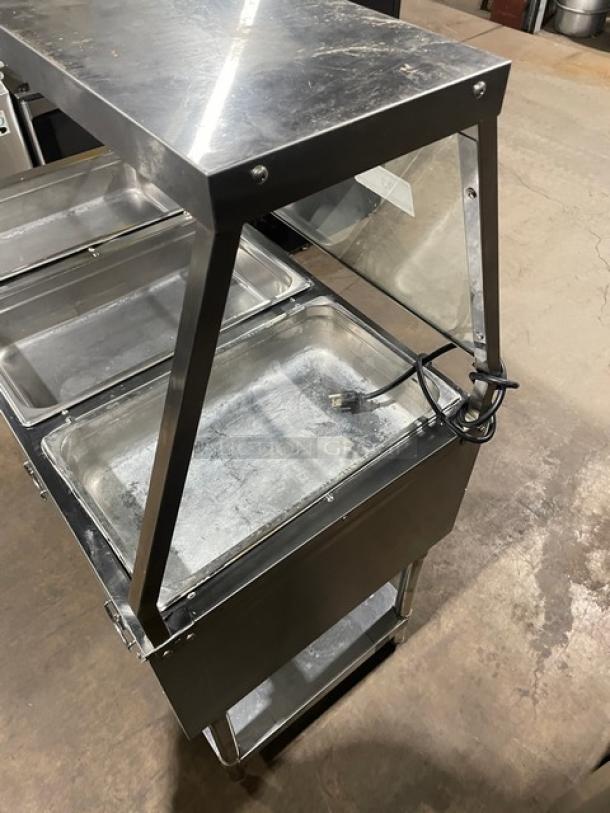 Serv-Ware stainless steel hot food table, model EST3-1, with three open wells, sneeze guard, and sturdy legs. Electric, 120V.