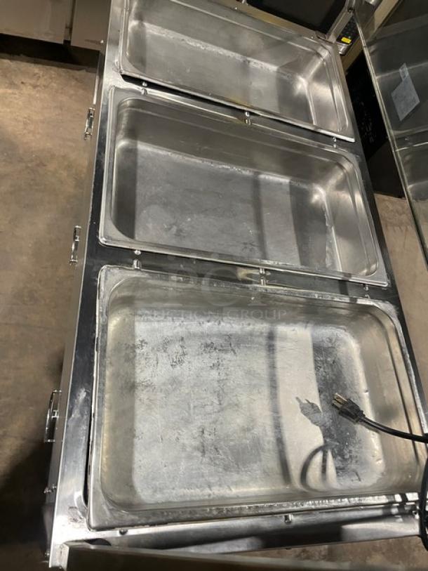 Serv-Ware EST3-1 stainless steel hot food table with 3 open wells, sneeze guard, on legs, electric, 120V, model number visible.