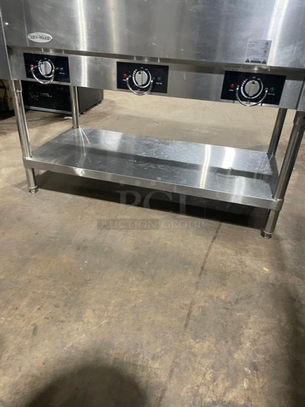 Serv-Ware EST3-1 stainless steel hot food table with 3 open wells, sneeze guard, and legs. Electric-powered, 120V.