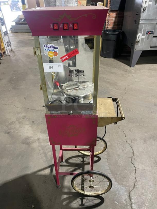 Great Northern Popcorn pink popcorn machine on casters and legs, features control switches, model signage, used condition.