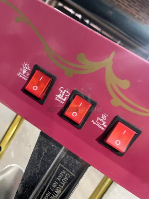 Great Northern Popcorn commercial pink popcorn machine controls with switches for warming, stirring, and pot heater functions.