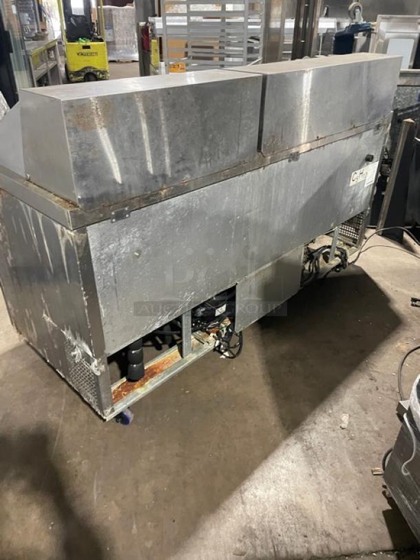 Atosa MSF8308GR 3-door refrigerated prep table, stainless steel, electric, on casters, showing signs of wear.