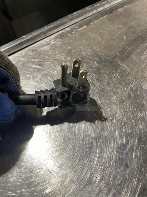 Close-up of an electrical plug for an Atosa Mega Top Series refrigerated prep table, model MSF8308GR, showing metal prongs.