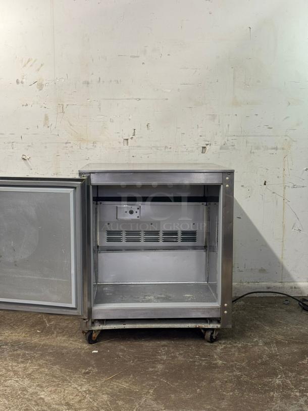 Follett REV 4-ADA undercounter refrigerator, right hinge, open door, stainless steel, visible shelves, moderate wear.