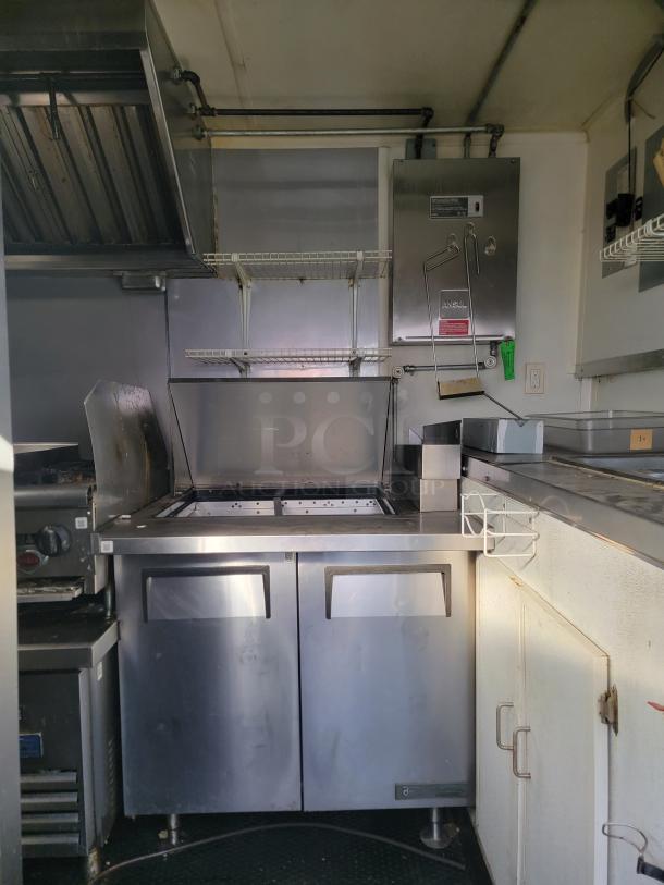 2020 Diamond Cargo food trailer interior; features commercial Wells cooking surface, stainless steel prep tables, and refrigeration units.