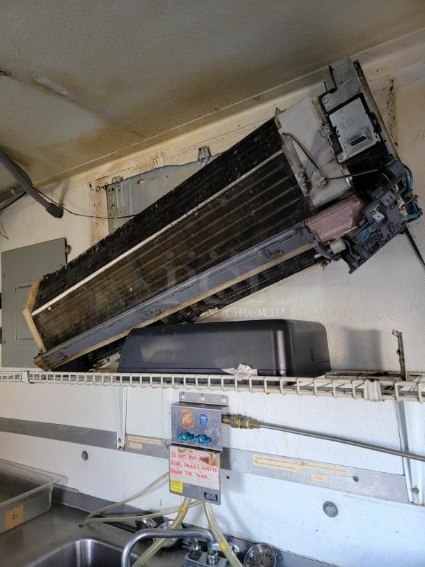 Interior of 2020 Diamond Cargo food trailer with a Mitsubishi A/C unit, sink, and utility connections. Visible wear on surfaces.