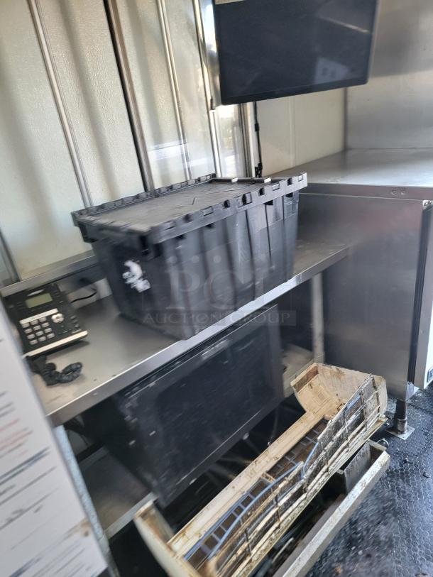 Interior of 2020 Diamond Cargo food trailer showing storage bins, shelves, and a mounted electronic device. Dusty surfaces suggest moderate use.