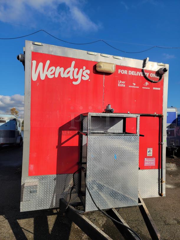 2021 28' Texino Food Trailer, red exterior, branded with Wendy's, featuring propane shut-off panel. Ideal for mobile food business.