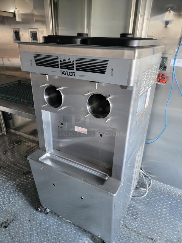 Taylor commercial ice cream machine inside 2021 Texino Food Trailer. Stainless steel finish, dual dispensers, well-maintained.