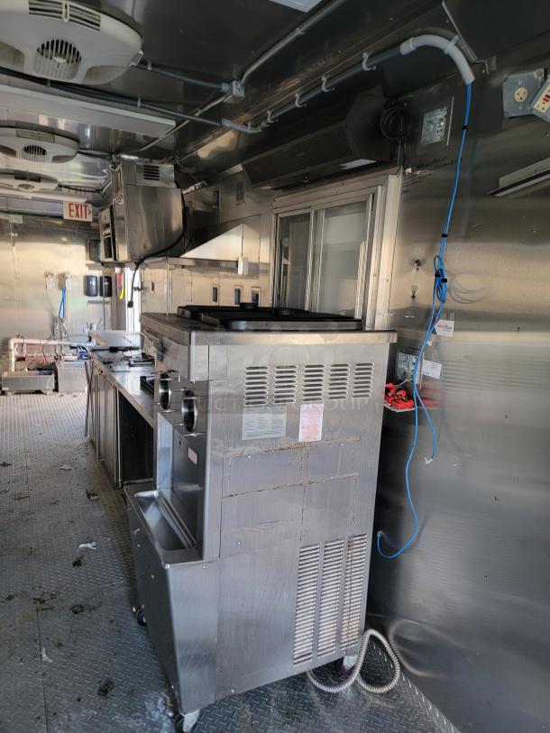 2021 Texino 28' food trailer interior with clamshell grill, Henny Penny fryer, Turbo Air, and Hoshizaki refrigeration units.