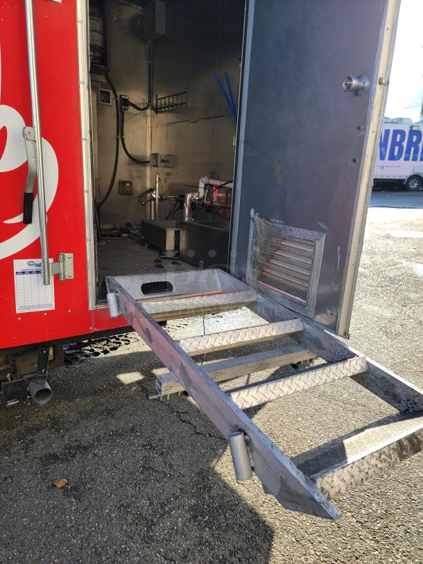 2021 Texino 28' Food Trailer with open door, revealing sturdy interior setup. Visible exhaust hood system. Exterior red with service labels.