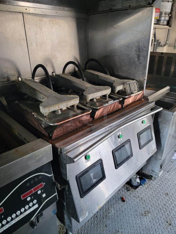 2021 28' Texino Food Trailer interior showing commercial clamshell grill and control panel, well-maintained and ready for use.