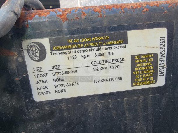 Sticker on food trailer showing tire and loading information; cargo weight limit 1,520 kg (3,350 lbs), tire size ST235-80-R16.