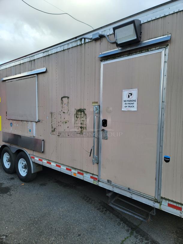 Quality 24' food trailer with stainless steel construction. Visible external wear and "No Parking" sign on door. Turbo Air refrigeration included.