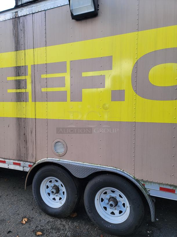 24' Quality food trailer with dual axles and brown exterior. Visible wear, yellow markings; equipped with Turbo Air refrigeration.