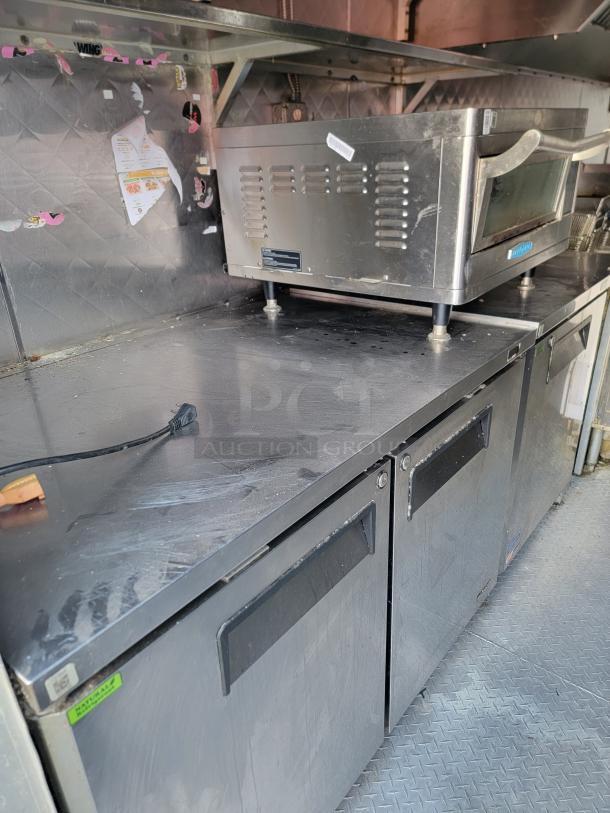 Professional-grade 24' Quality food trailer interior with stainless steel counters and Turbo Air refrigeration, showing NSF-certified equipment.