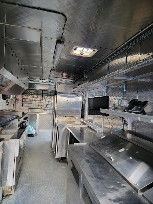 Stainless steel interior of a 24' Quality food trailer with Turbo Air refrigeration, NSF-certified equipment, ready for use.