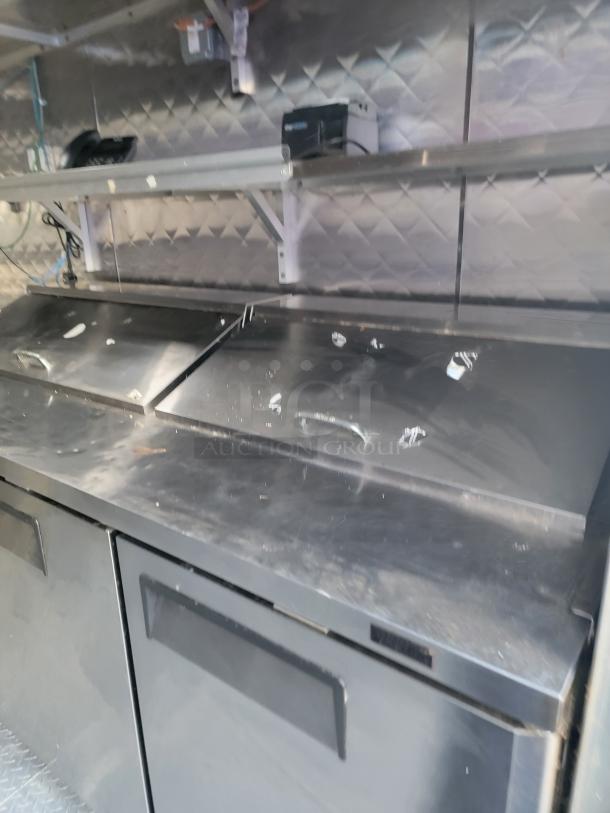 Fully equipped 24' Quality food trailer with stainless steel interiors and Turbo Air refrigeration; ready for mobile service.