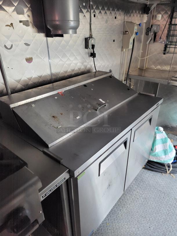 Professional-grade 24' Quality food trailer interior with stainless steel surfaces and Turbo Air refrigeration system.