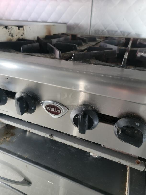 Stainless steel Wells gas stove in a 24' Quality food trailer. Professional-grade, with control knobs shown.
