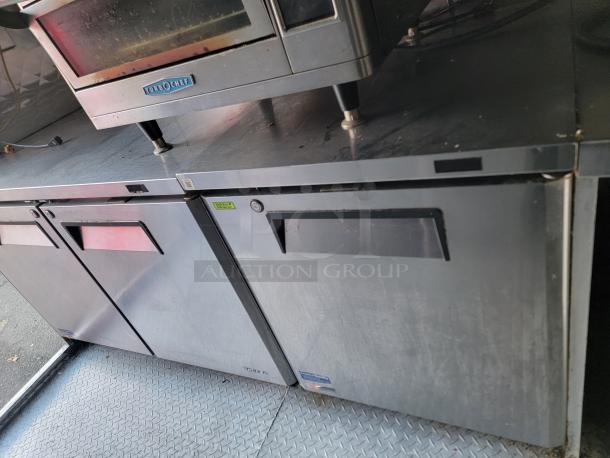 Professional-grade 24' Quality food trailer interior, featuring durable stainless steel and Turbo Air refrigeration equipment.