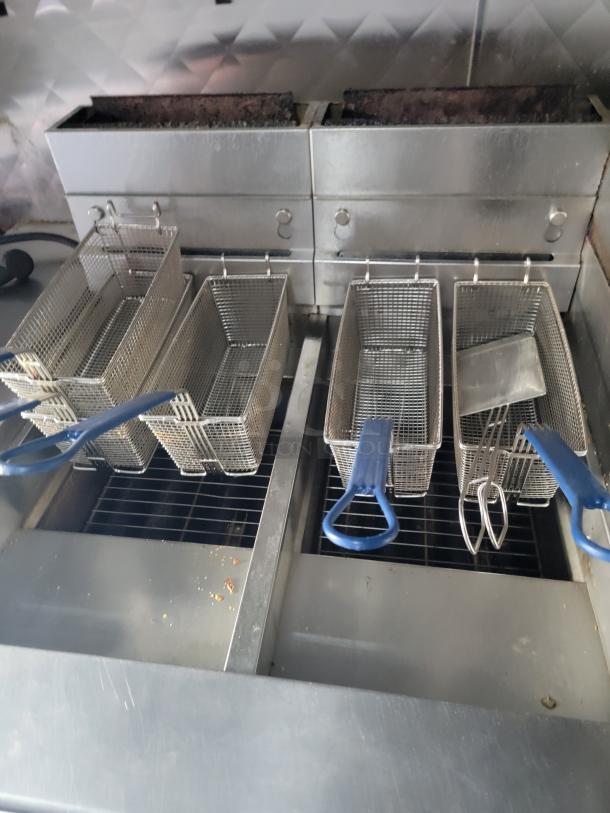 Professional-grade fryer setup in a 24' Quality food trailer, featuring multiple baskets and stainless steel construction. Ideal for high-volume service.