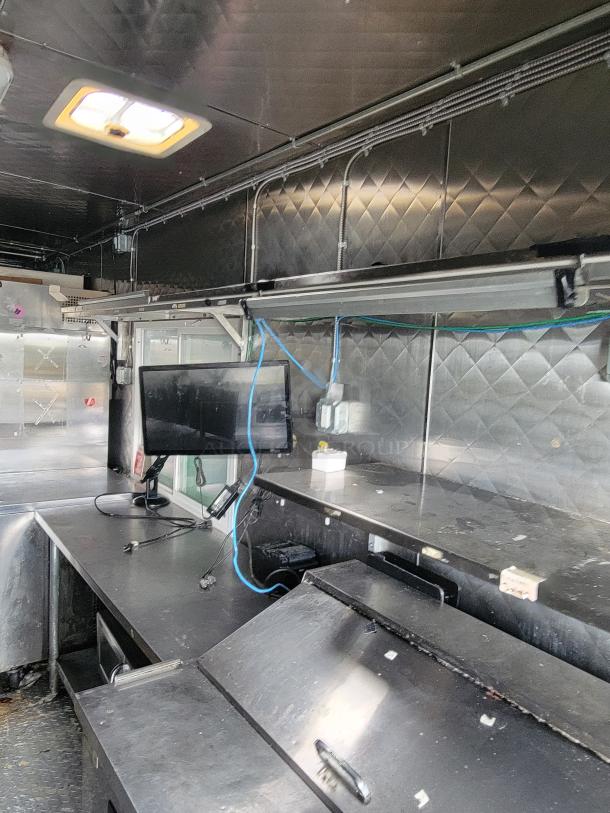 2020 Quality 24' food trailer interior, featuring stainless steel surfaces, shelves, and electrical outlets. Used condition.