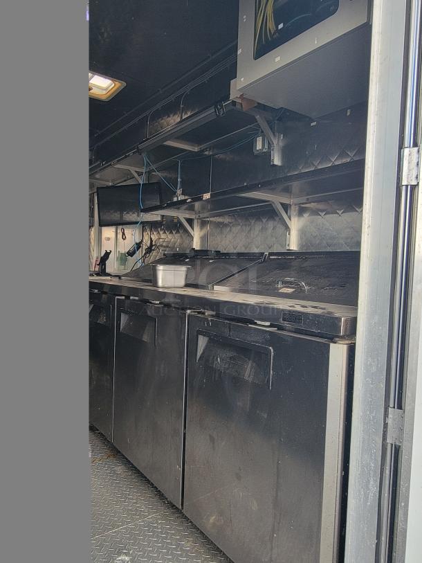2020 Quality 24' food trailer interior, equipped with stainless steel counters and kitchen appliances, good condition.
