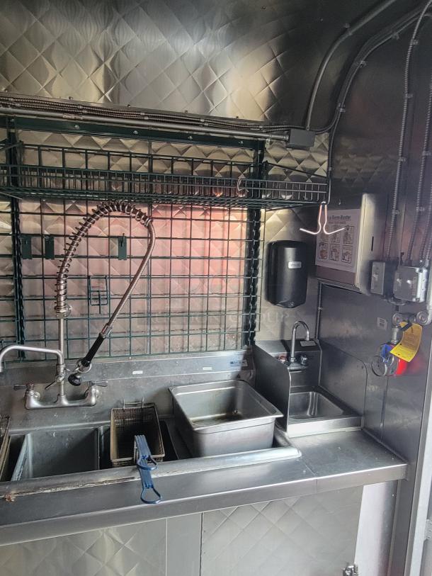 2020 Quality 24' food trailer interior with stainless steel sink, fryer, and storage; maintained, ready for business.