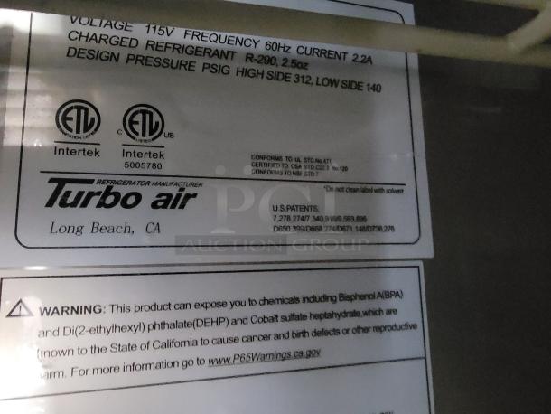 Warning label on Turbo Air refrigeration unit. Indicates refrigerant details, pressure specs, and potential chemical exposure.