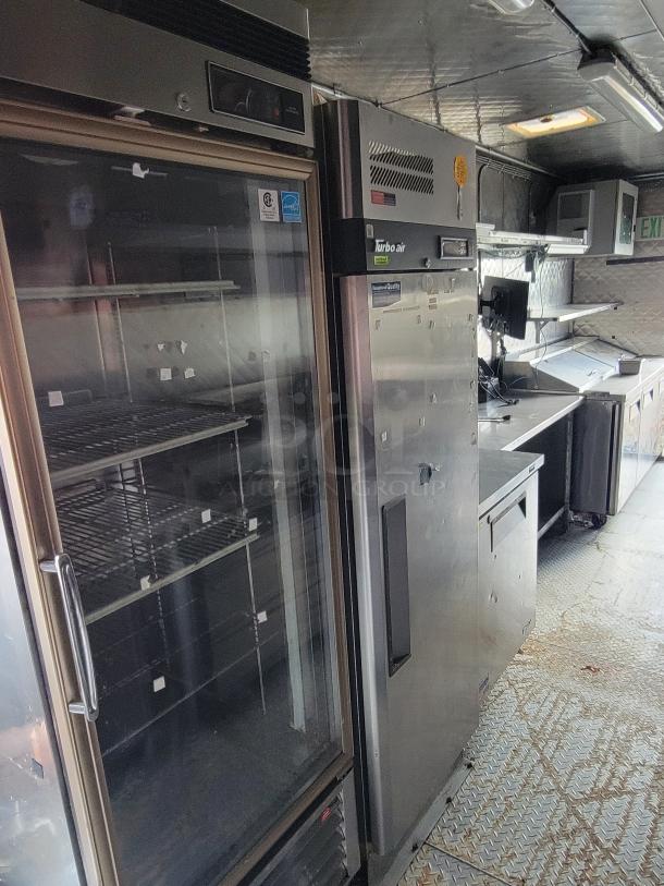 2020 24' Quality Food Trailer interior, featuring stainless steel appliances, refrigeration units, and prep counters. Fully equipped, excellent condition.