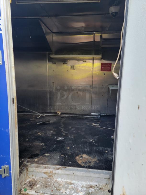 2019 Quality 24' empty food trailer interior with stainless steel walls, overhead vent, and visible electric outlets. Good condition.
