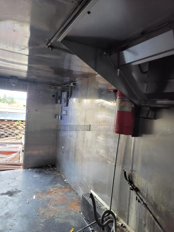 2019 Quality 24' empty food trailer interior, clean metal surfaces, equipped with exhaust system, ready for customization.