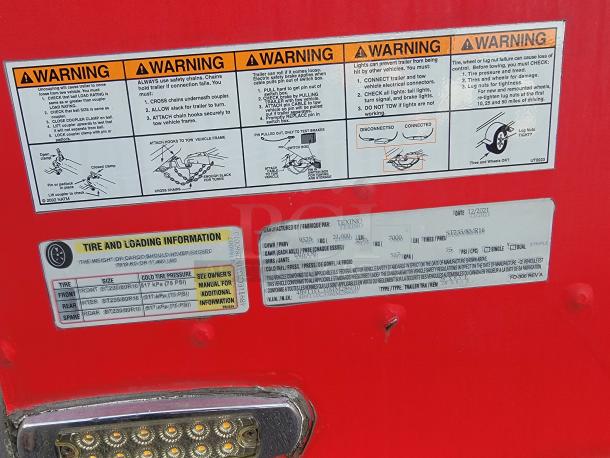 Red warning and information labels on a 2021 Texino food trailer detail safety guidelines and tire loading specs. Multiple cautions provided.