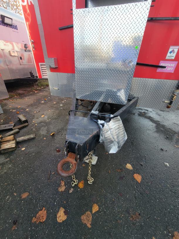 2021 Texino 28' food trailer hitch and front, showing diamond plate cover and red trailer body, ideal for mobile food service.