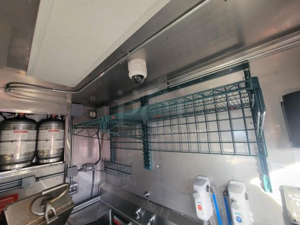 Interior view of a 2021 Texino 28' food trailer; includes wire shelving, stainless steel surfaces, and fire suppression system.