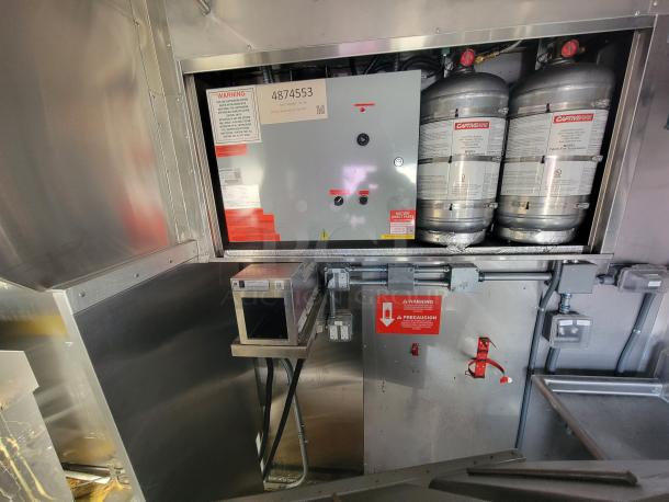 2021 Texino 28' stainless steel food trailer interior, featuring CaptiveAire ventilation and control panel with safety labels.