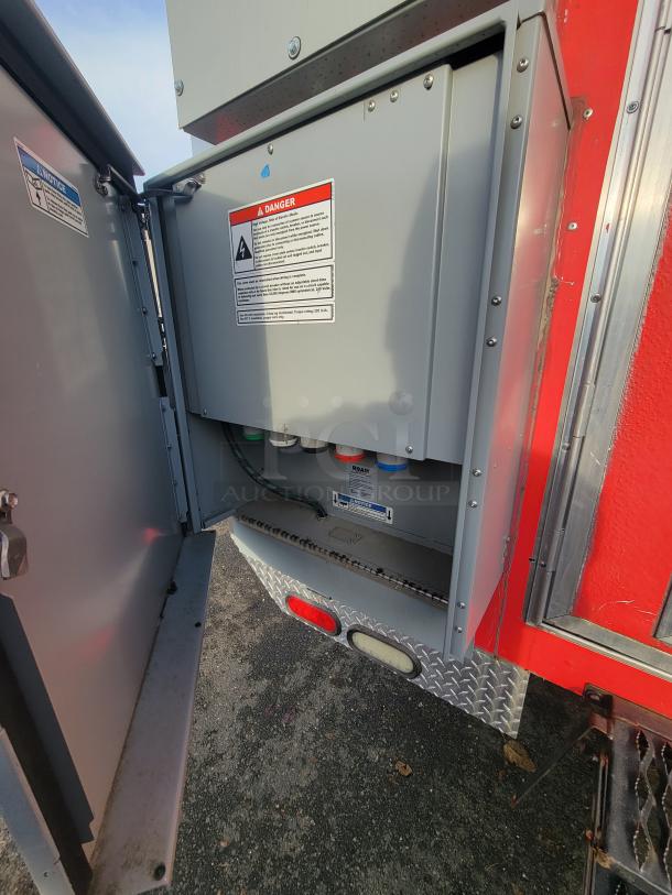 Interior view of a 2021 Texino 28-foot food trailer's electrical panel, featuring safety warnings and standard electrical components.
