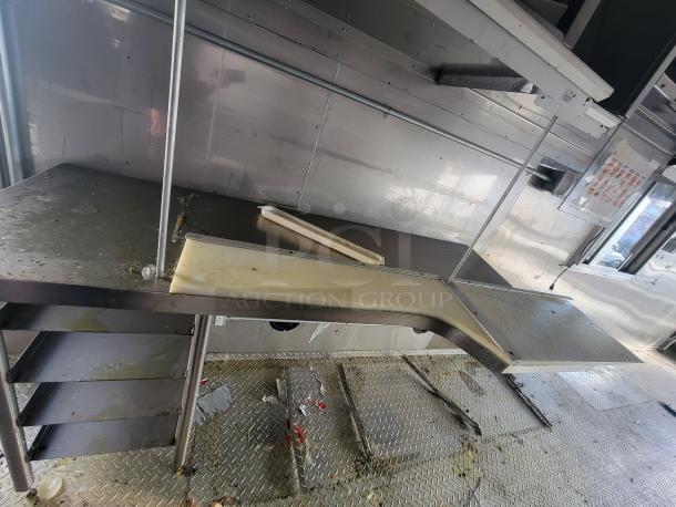 2021 Texino 28’ food trailer interior, stainless steel setup. Includes shelving and prep area. Previously a Wendy's unit.