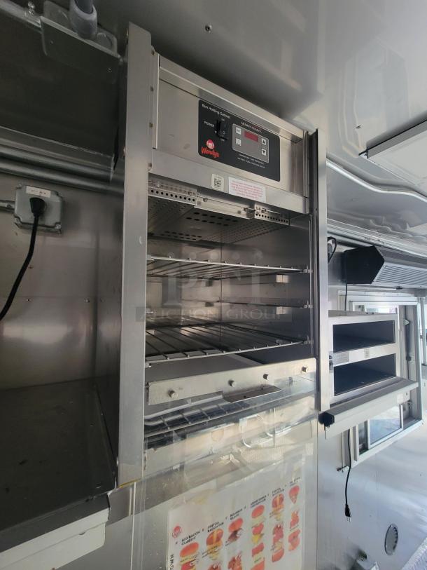 Interior of a Texino 28' food trailer, featuring a Henny Penny heated holding cabinet with Wendy's branding. Stainless steel setup.