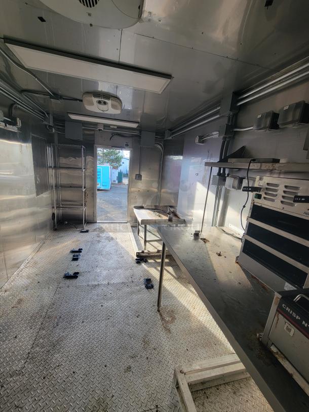 2021 Texino 28' food trailer interior, stainless steel walls, commercial kitchen setup with Crisp N' Hold station, ready for use.