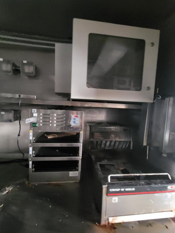 2021 Texino 28' food trailer interior, featuring an Antunes Crisp N' Hold station, heated holding cabinet, and contact toaster.