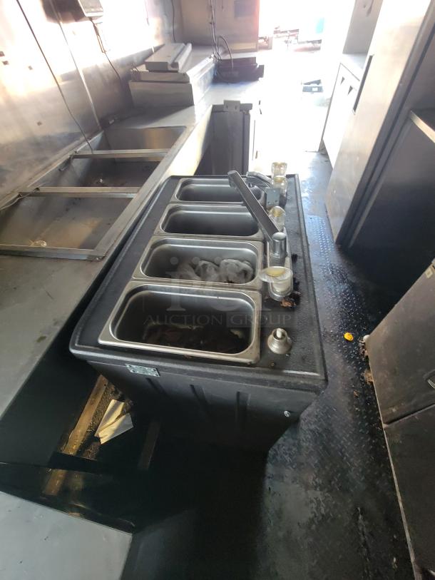 2019 Quality 24' food trailer interior with stainless steel sink, prep stations, and storage units. Fully equipped for mobile kitchen use.