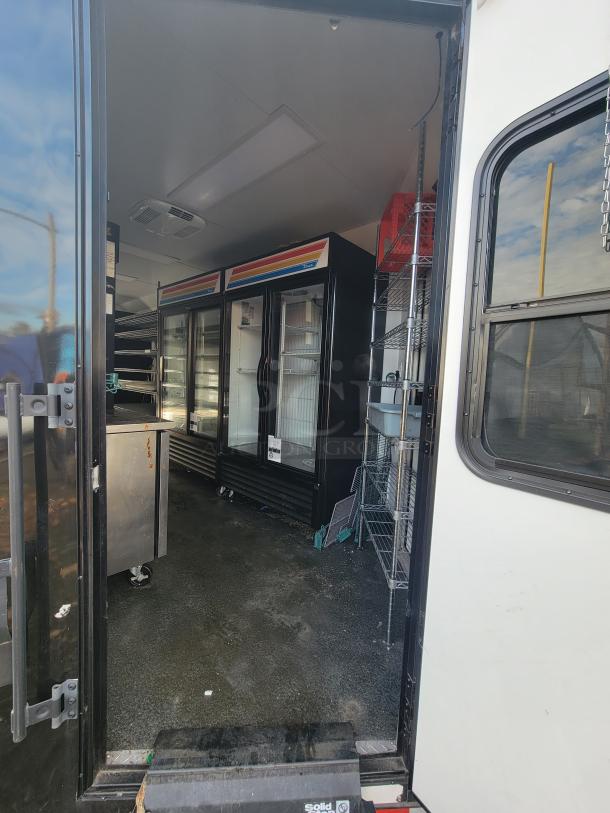 2021 SDG 20' mobile ghost kitchen trailer, dual-axle, equipped with premium commercial fridges, shelves, and storage for delivery setup.